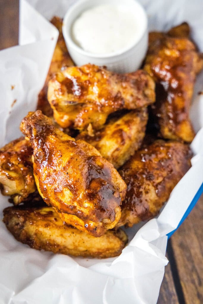 chicken wings in a basket with ranch dipping sauce