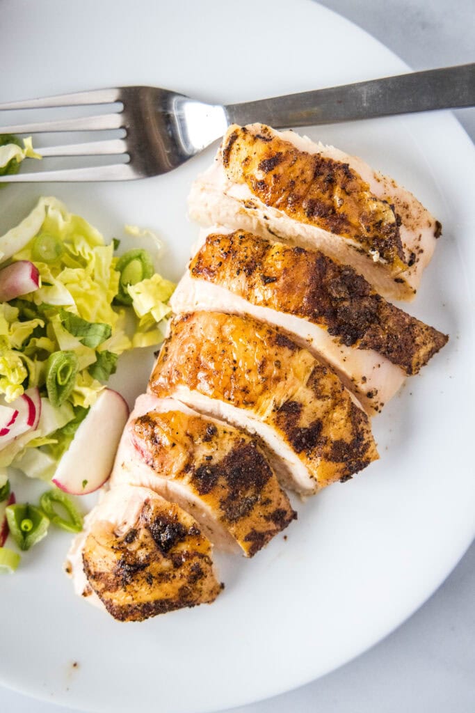 looking down on white plate with slices of chicken
