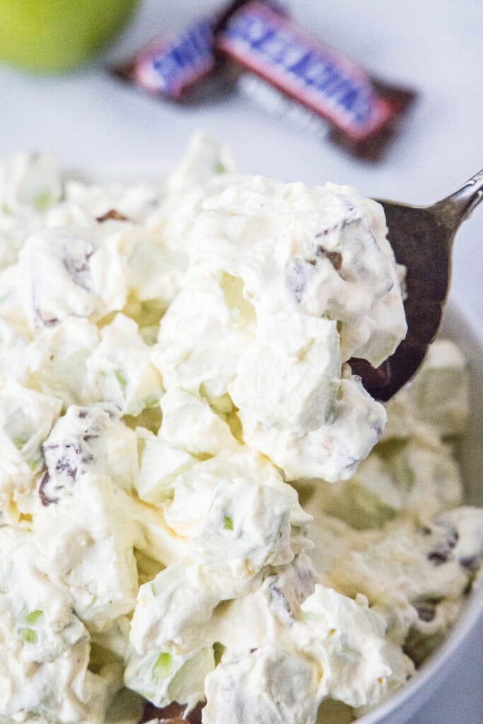 spooning candy salad out of serving bowl