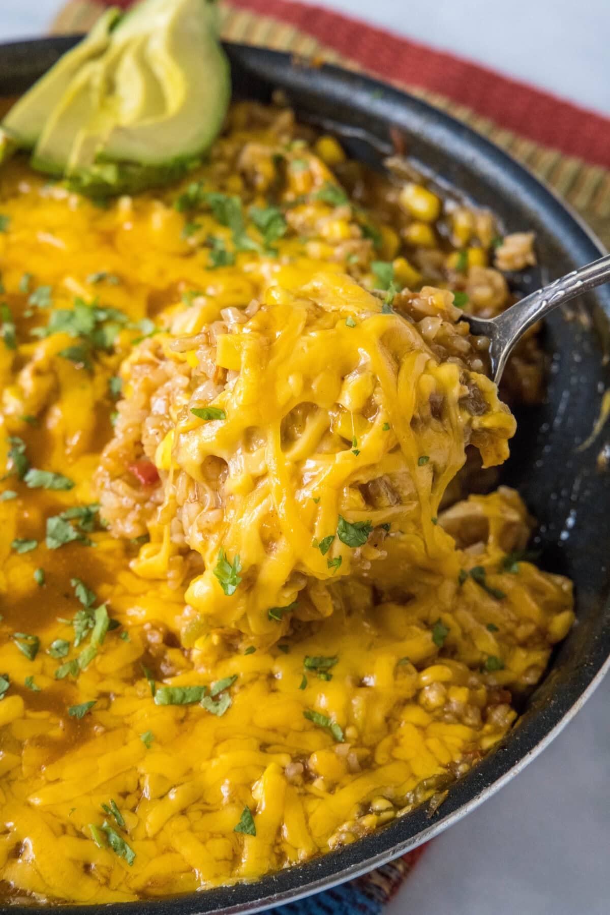 scooping mexican chicken and rice out of skillet