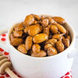 close up spicy honey roasted almonds in white bowl