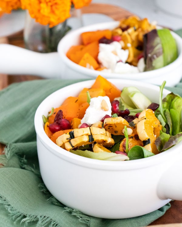 salad in white bowl with flowers near by