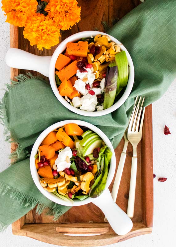 2 bowls of goat cheese sald on wooden tray