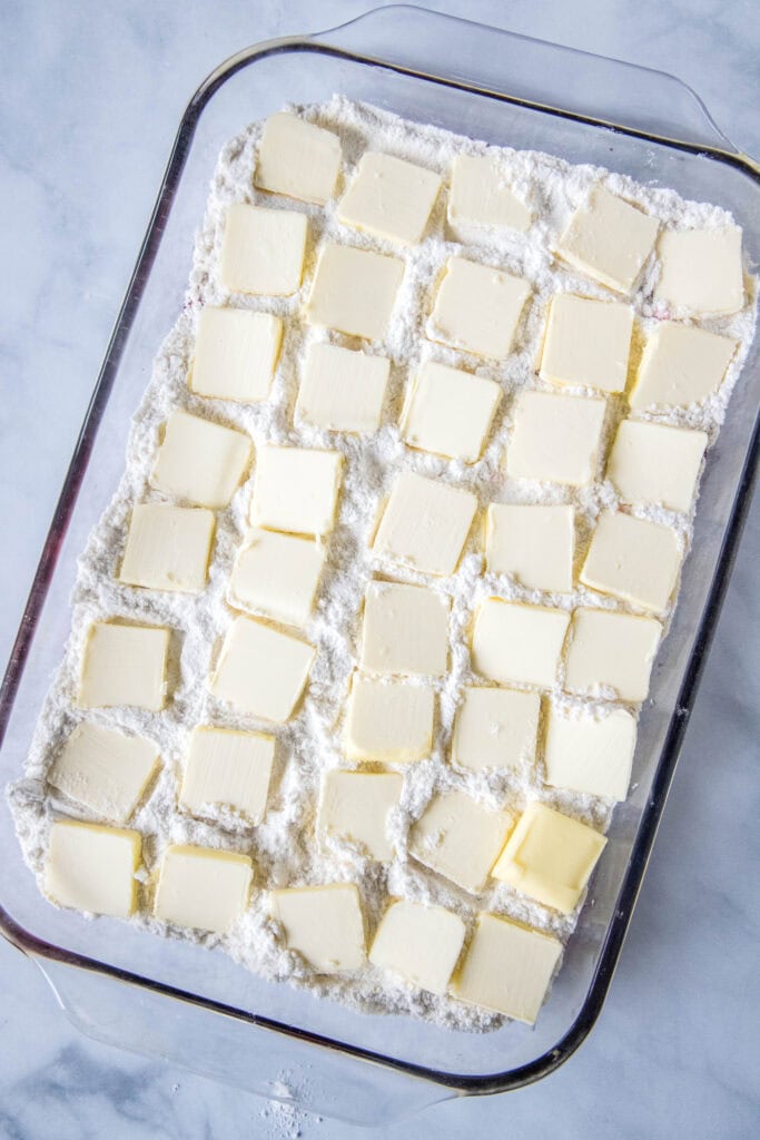 pats of butter ontop of cake mix in baking pan