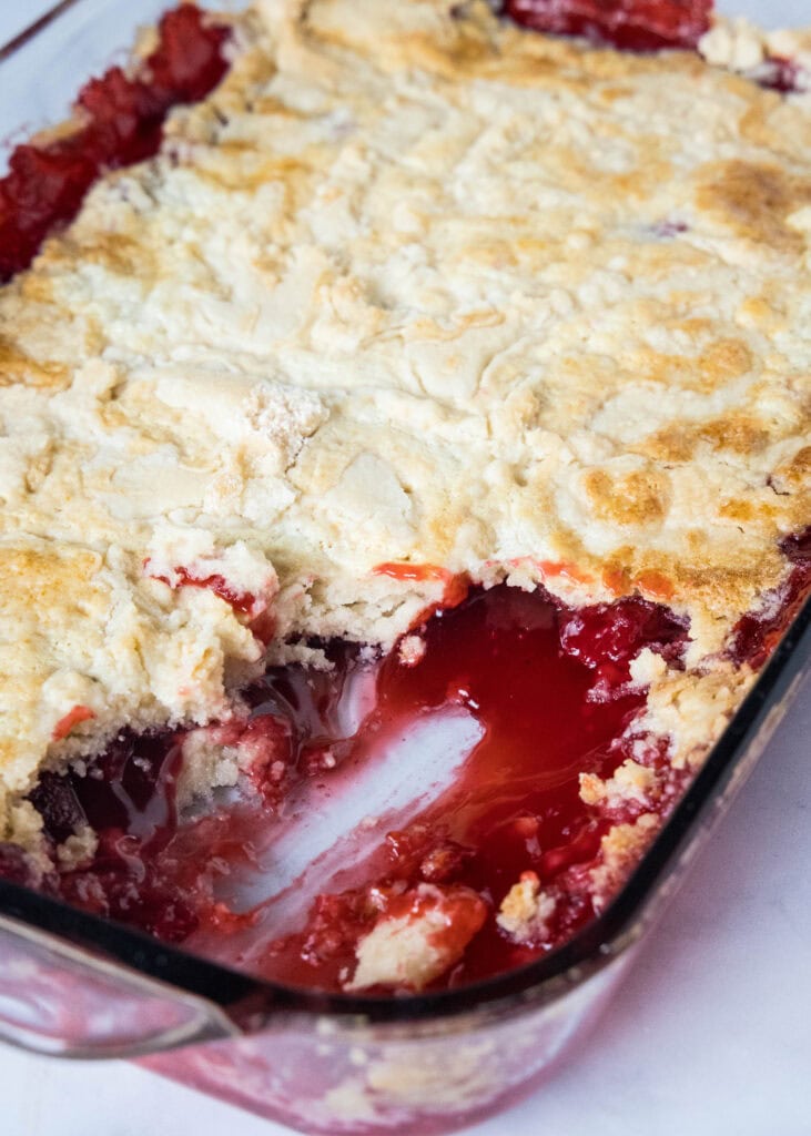 strawberry dump cake baked in pan with pieces missing