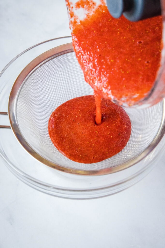 pouring strawberry juice into strainer