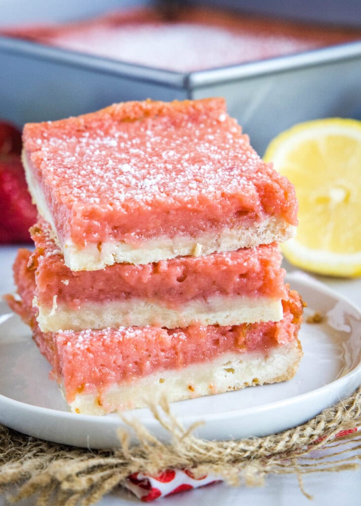 strawberry lemon bars stacked on a plate