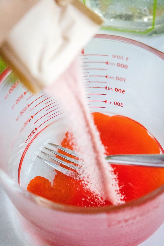 adding jello mix to hot water.