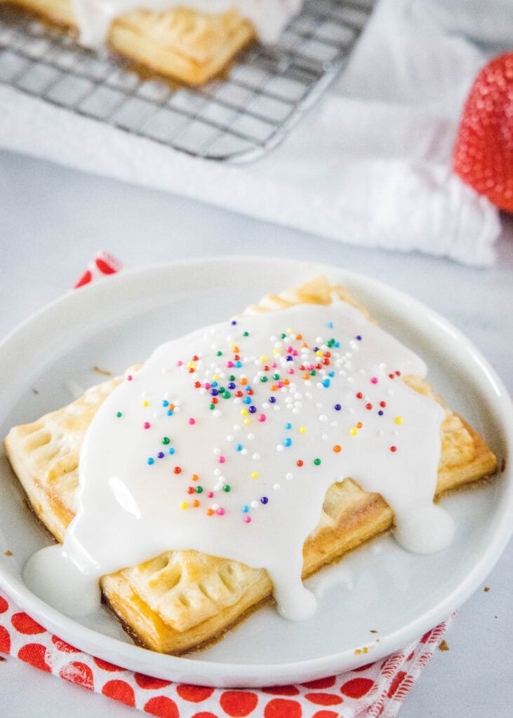 strawberry pop tart with glaze on a white plate