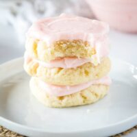 a stack of sugar cookies with a bite taken out of the top one
