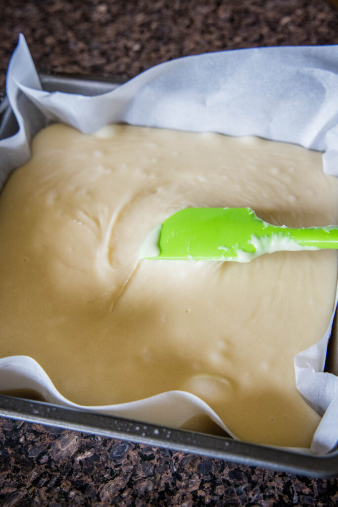 spreading sugar cookie fudge into a pan