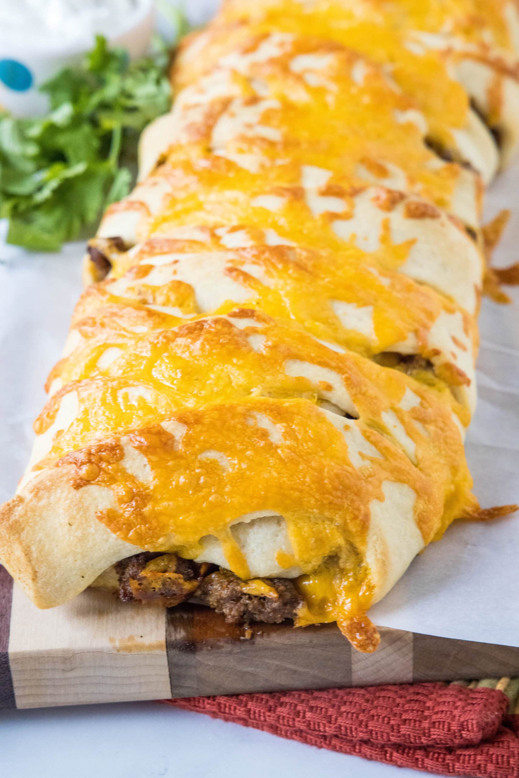 A taco braid topped with melted cheese.