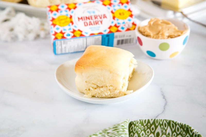 roll on white plate with cinnamon honey butter next to it