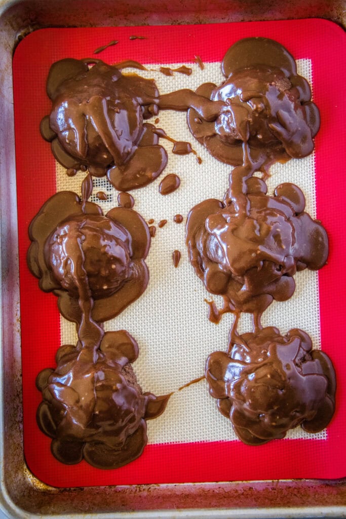 looking down on a tray of cookies with frosting poured all over them.
