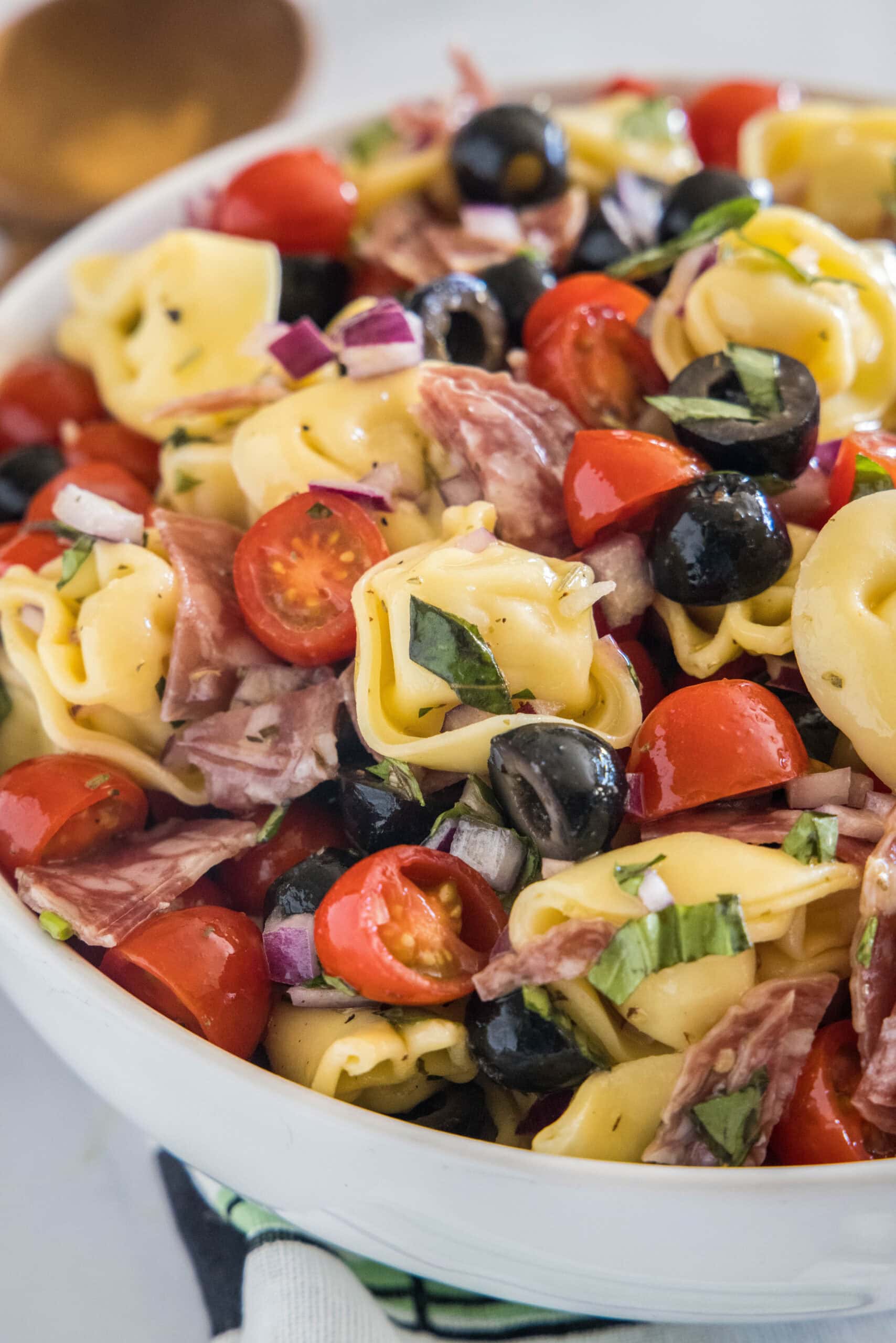 Tortellini pasta salad in a white bowl.