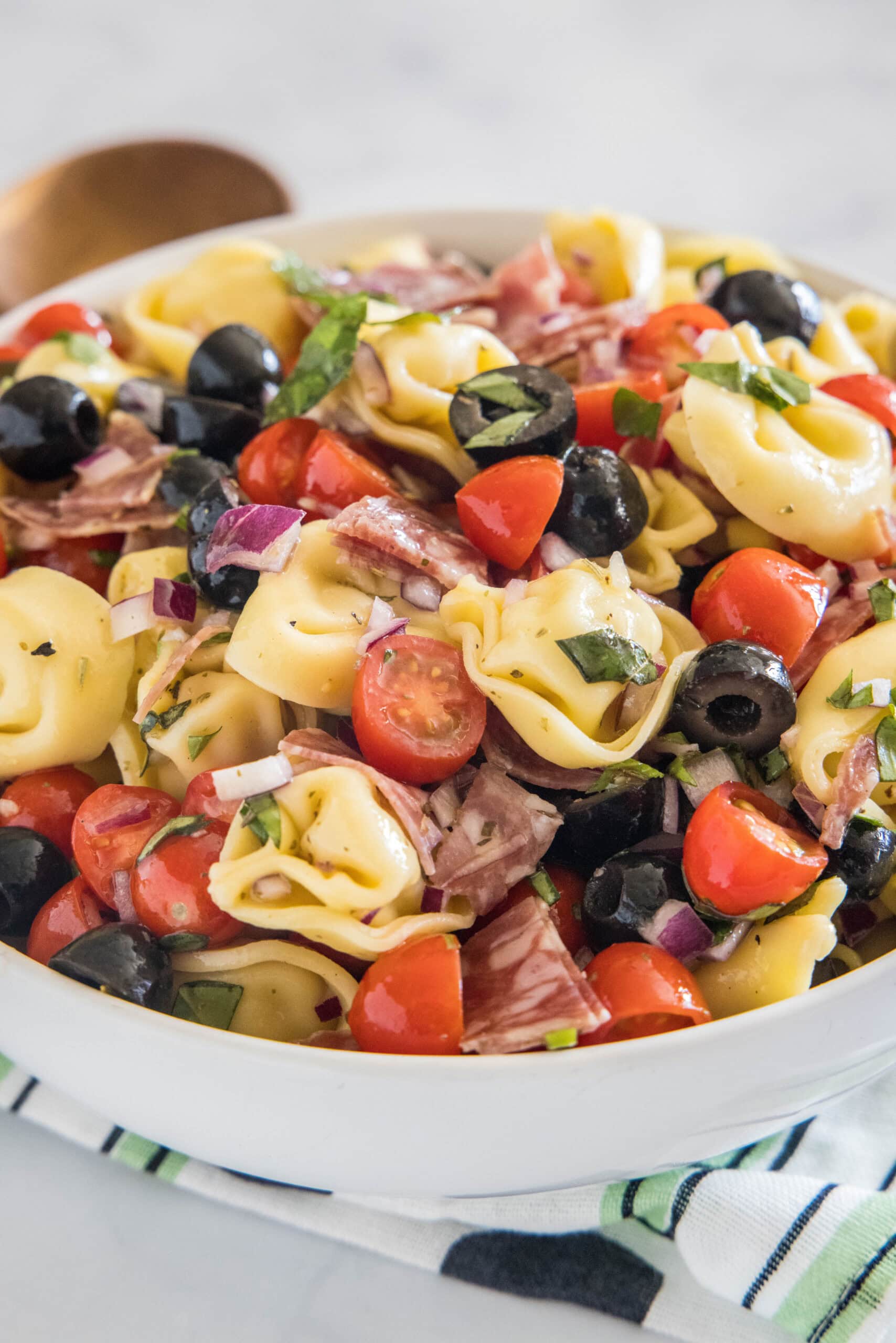 Tortellini pasta salad in a white bowl.
