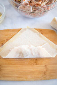 step 1 folding the bottom over the egg roll filling