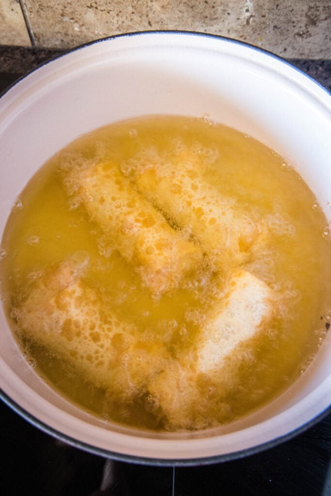 egg rolls cooking in hot oil
