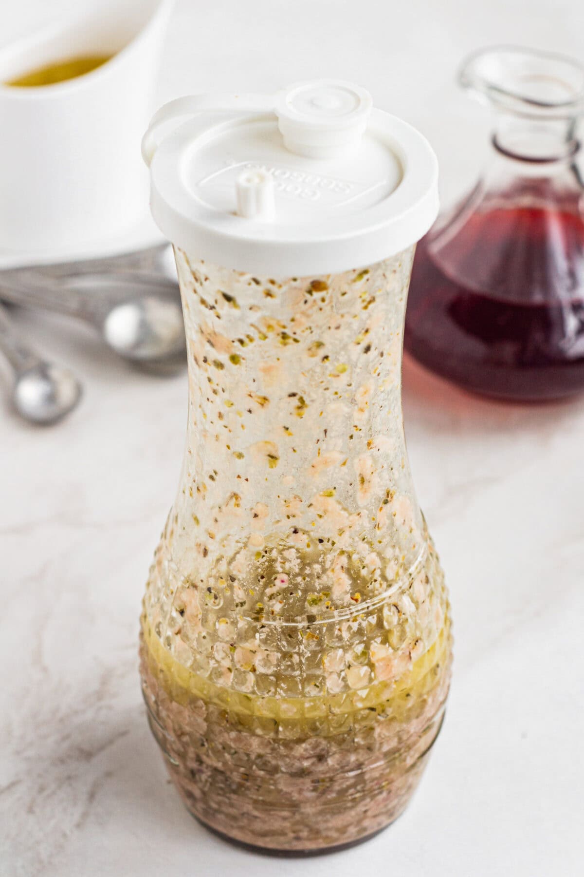 Emulsified red wine vinaigrette inside a glass carafe.