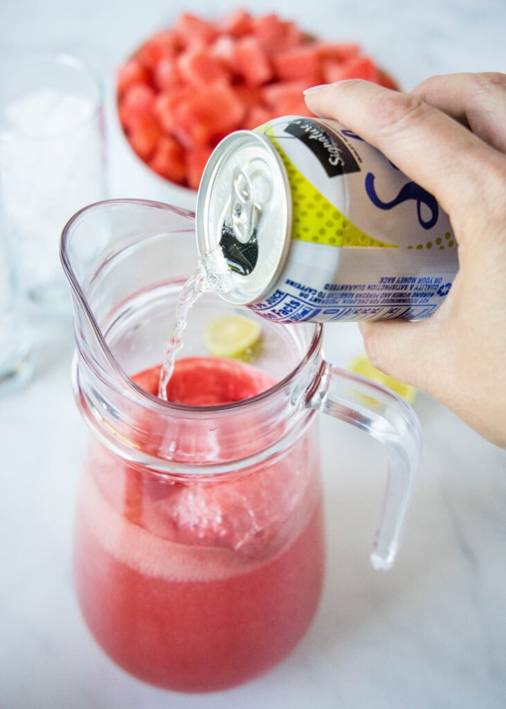 pouring sparking water into a pitcher