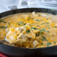 a skillet with chicken and cheese