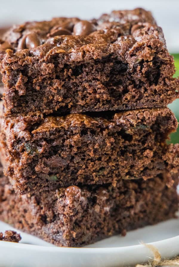 cropped close up stack of zucchini brownies on white plate